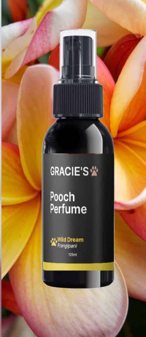 Gracie's Pooch Perfume Frangipani bottle among frangipani flowers